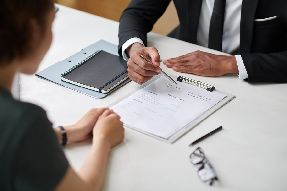 Human resources manager explaining candidate how to fill labor contract